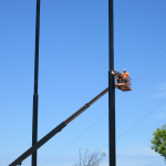 Installation crew installing cabling to support the golf netting