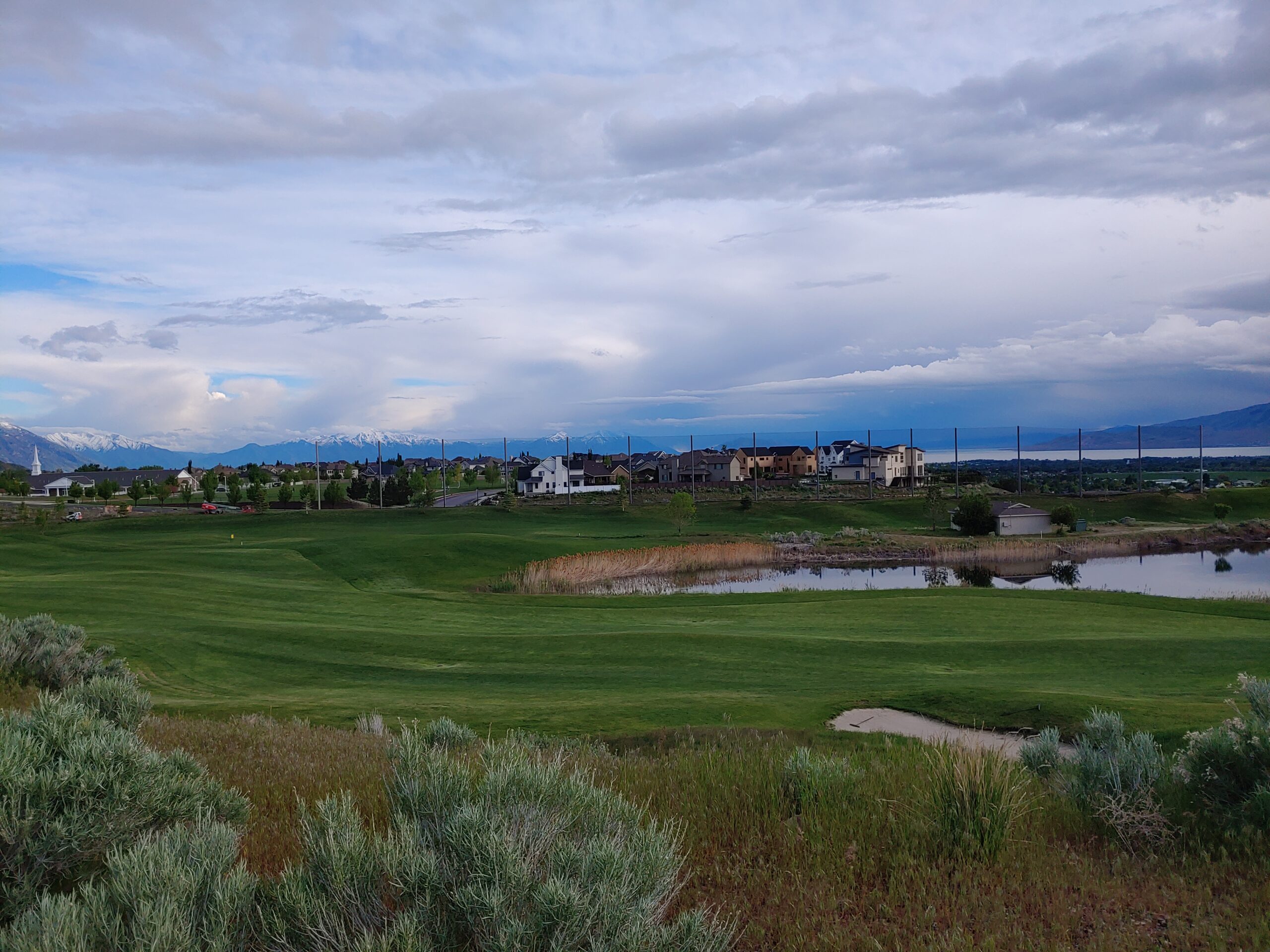 Golf course with barrier netting and mountains in the distance