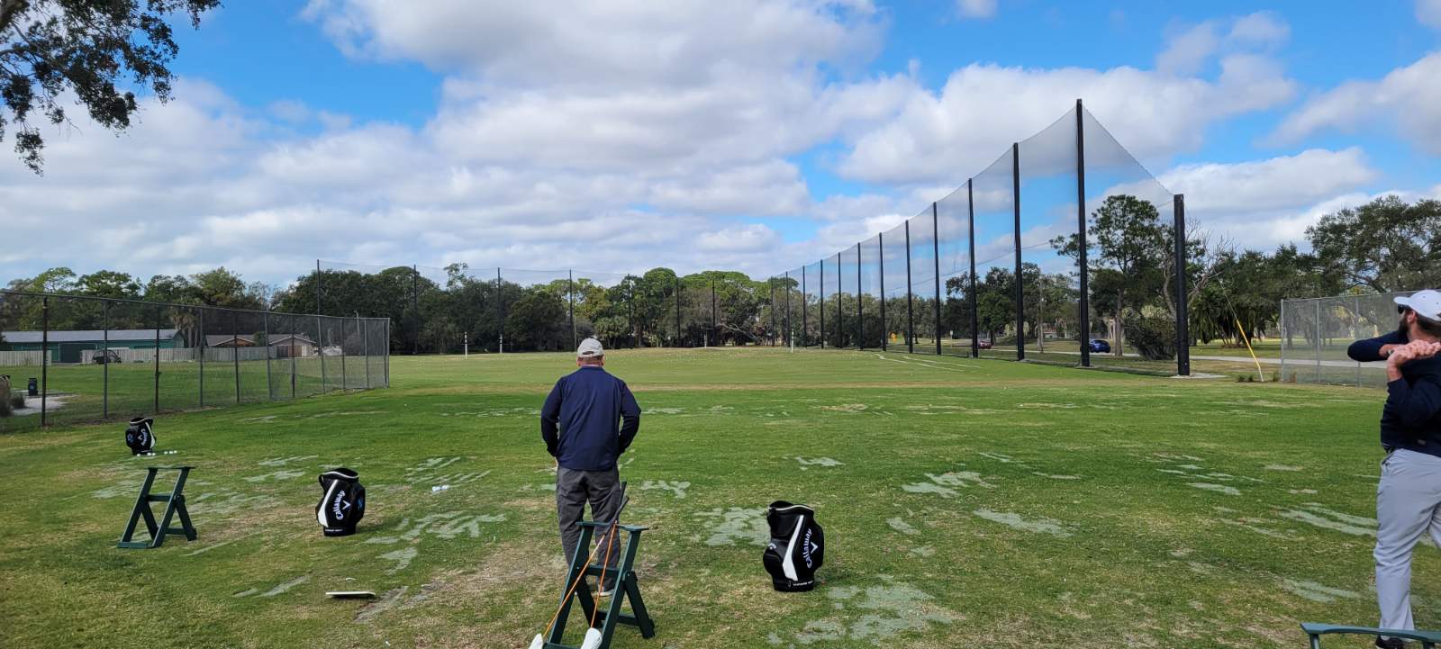 Golf practice: nets, clubs, and balls on the green